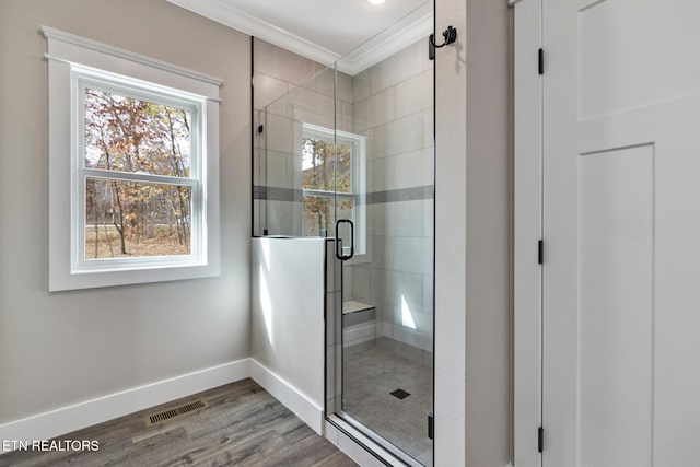 bathroom featuring walk in shower, wood-type flooring, and ornamental molding