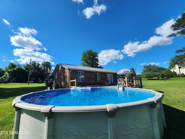 view of swimming pool with a yard