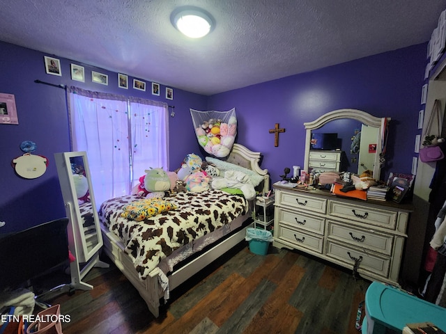 bedroom with dark hardwood / wood-style floors and a textured ceiling