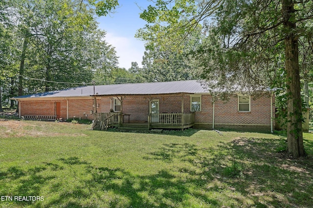 rear view of house featuring a yard