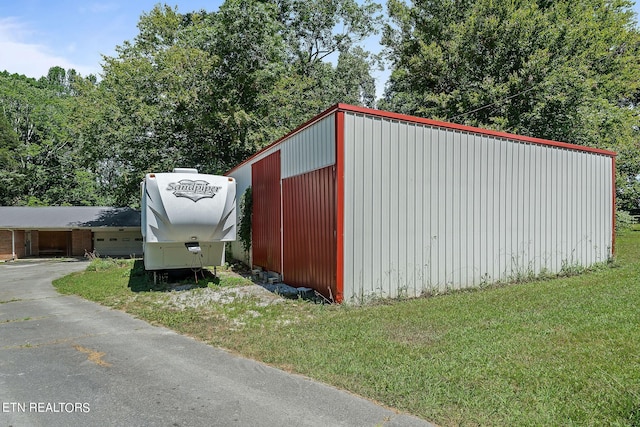 view of outdoor structure with a garage and a lawn