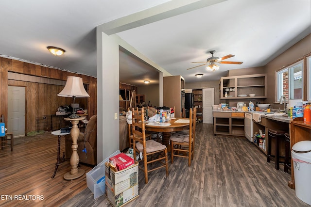 dining space featuring ceiling fan, dark hardwood / wood-style flooring, and wood walls