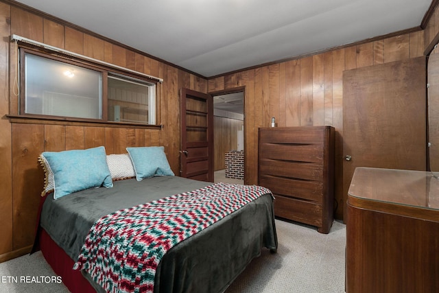 bedroom featuring light carpet, wood walls, and ornamental molding