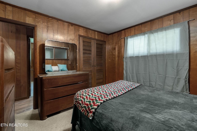 carpeted bedroom featuring a closet, ornamental molding, and wooden walls