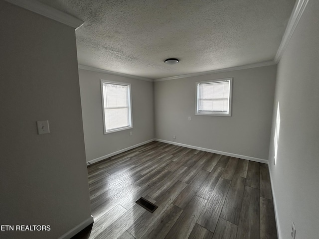 spare room with ornamental molding, dark wood-type flooring, and a wealth of natural light