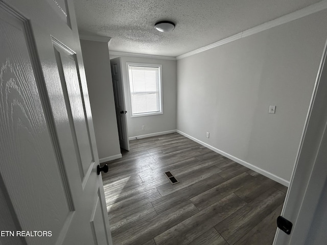 spare room with dark hardwood / wood-style flooring, a textured ceiling, and ornamental molding