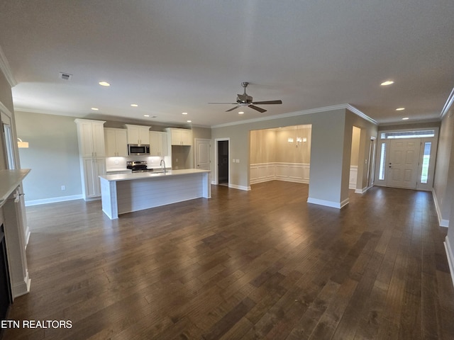 unfurnished living room featuring a sink, ceiling fan, ornamental molding, dark wood-type flooring, and visible vents