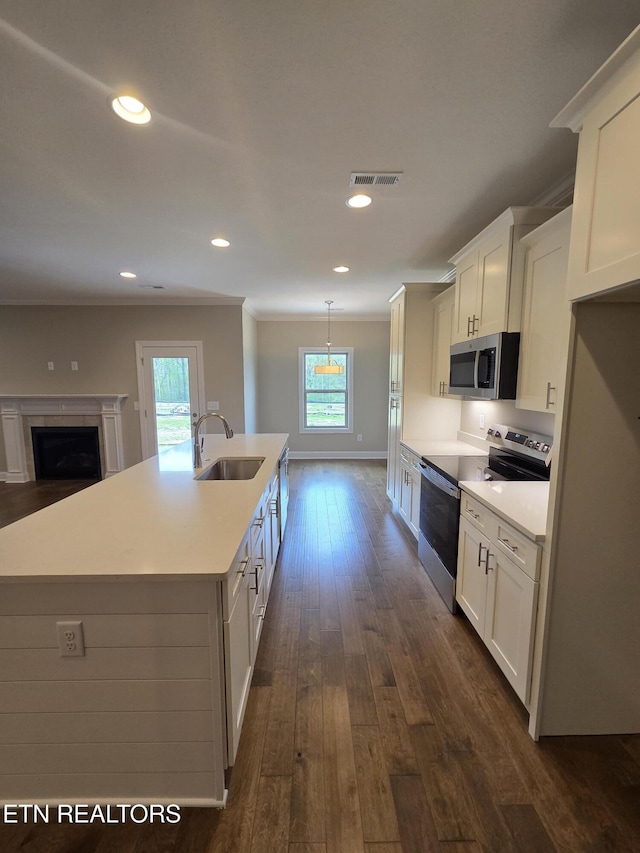 kitchen featuring appliances with stainless steel finishes, a sink, white cabinetry, and a healthy amount of sunlight