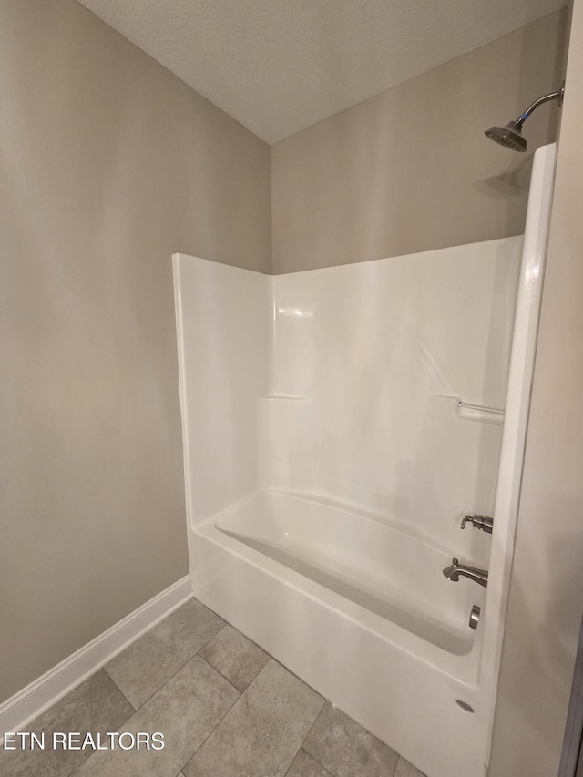 full bath featuring a textured ceiling, tile patterned flooring, baseboards, and  shower combination