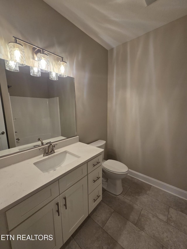 bathroom with toilet, vanity, and vaulted ceiling
