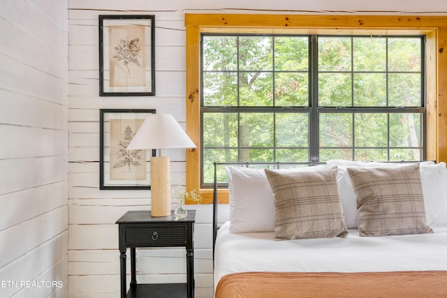 bedroom featuring wooden walls