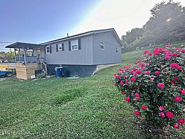 view of home's exterior featuring stairs and a lawn