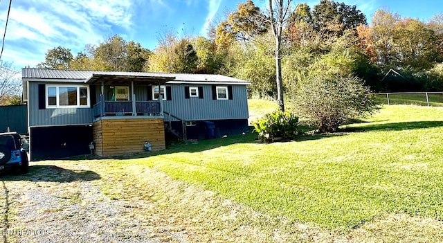 view of front of property featuring a garage, metal roof, a front yard, and driveway