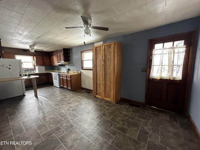 kitchen featuring under cabinet range hood, white appliances, a ceiling fan, light countertops, and brown cabinets