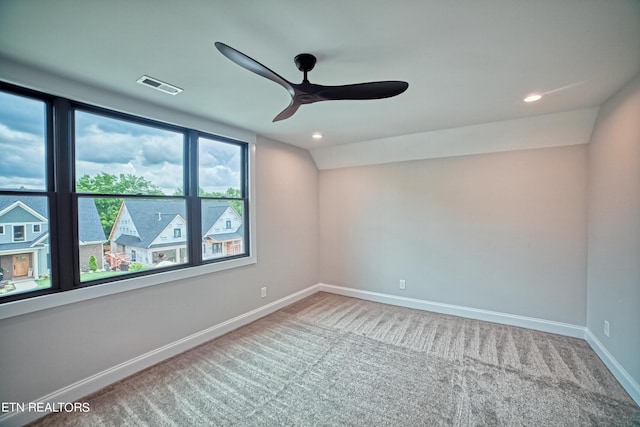 empty room with ceiling fan, carpet floors, and lofted ceiling