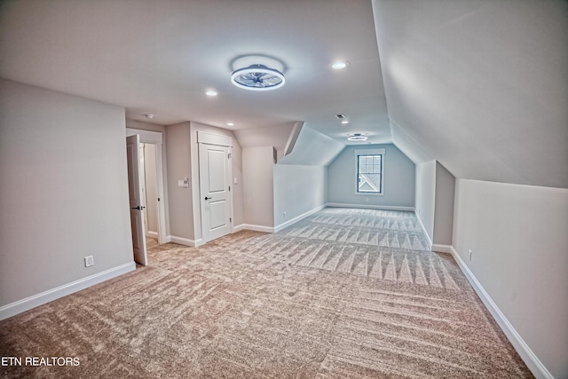 bonus room with light carpet and lofted ceiling