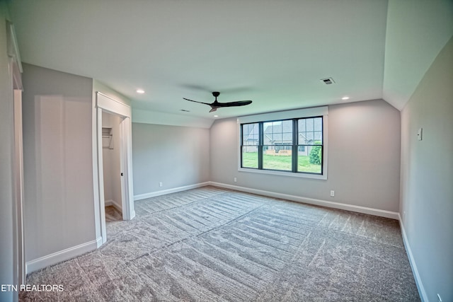 carpeted spare room with ceiling fan and lofted ceiling