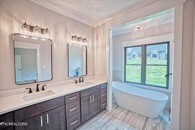 bathroom featuring vanity, an inviting chandelier, and a bathing tub