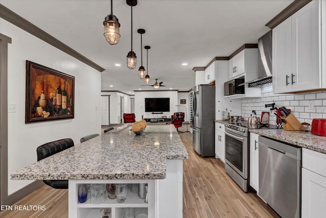 kitchen featuring white cabinetry, light stone countertops, stainless steel appliances, pendant lighting, and a breakfast bar area