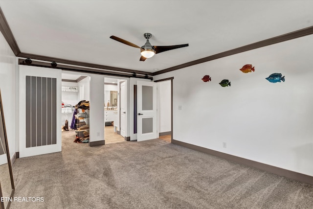 unfurnished bedroom with ensuite bath, light carpet, ceiling fan, and ornamental molding