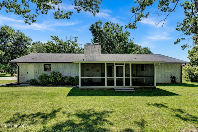 rear view of property with a sunroom and a yard