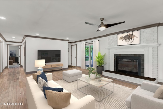 living room featuring a fireplace, hardwood / wood-style floors, ceiling fan, and ornamental molding