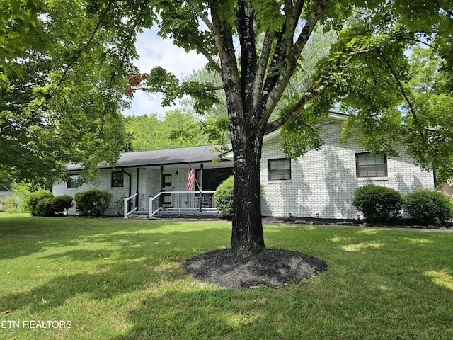 ranch-style house with a porch and a front lawn