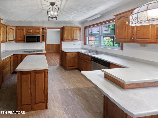 kitchen featuring a textured ceiling, an inviting chandelier, decorative light fixtures, and appliances with stainless steel finishes