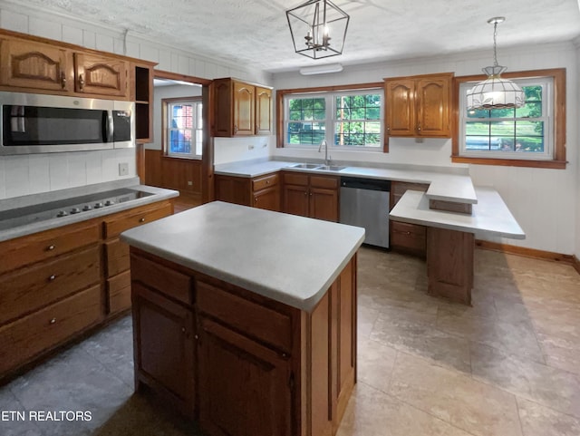 kitchen with a center island, decorative light fixtures, and appliances with stainless steel finishes