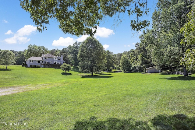 view of yard featuring a deck and an outdoor structure