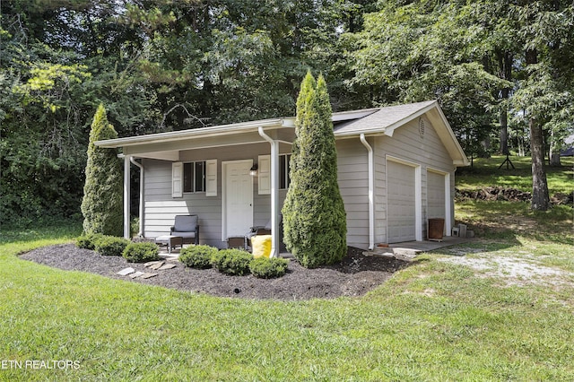 view of front of home with a front yard, a garage, and covered porch