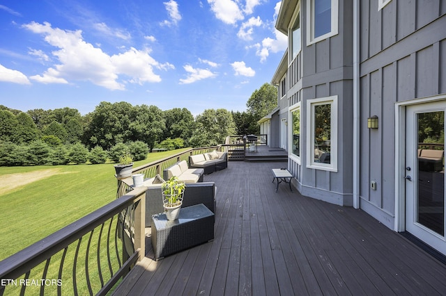 wooden terrace with outdoor lounge area and a lawn