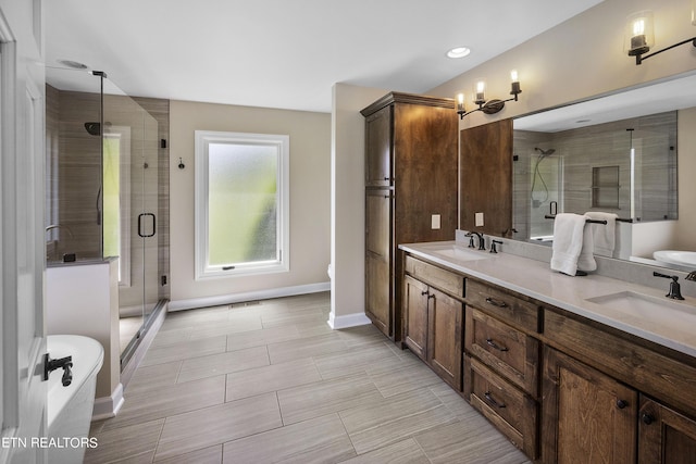 bathroom with a sink, baseboards, double vanity, and a shower stall