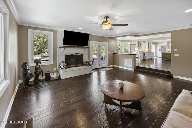 living room with a ceiling fan, a fireplace, dark wood-style flooring, and ornamental molding