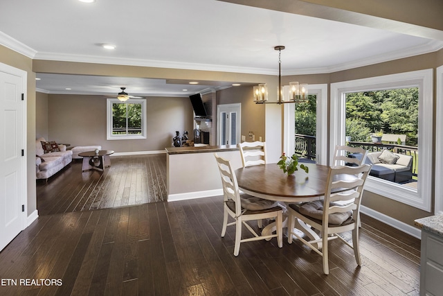 dining space with ceiling fan with notable chandelier, dark wood-type flooring, baseboards, and ornamental molding