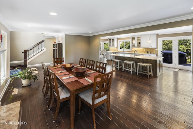 dining room featuring dark wood-type flooring, stairway, and plenty of natural light