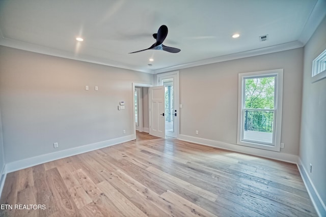 spare room with baseboards, light wood-type flooring, visible vents, and crown molding