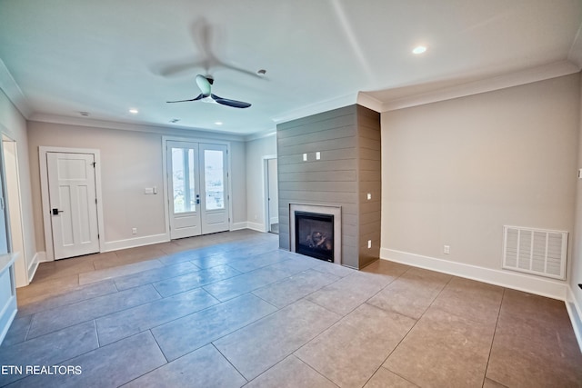 unfurnished living room with a large fireplace, visible vents, crown molding, and baseboards