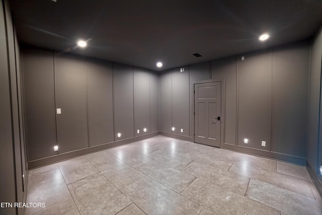 spare room featuring a decorative wall and recessed lighting