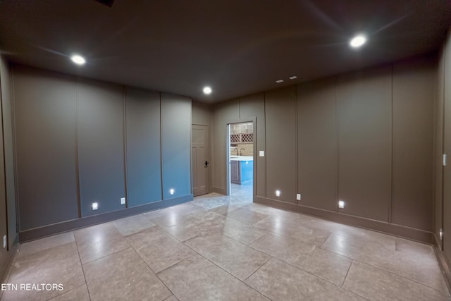 spare room featuring a decorative wall and recessed lighting