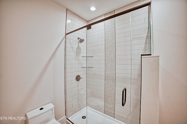 bathroom featuring a stall shower and toilet