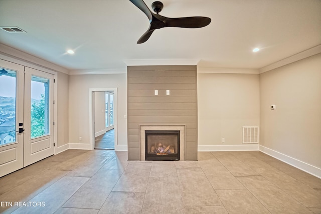 unfurnished living room with a large fireplace, visible vents, and crown molding