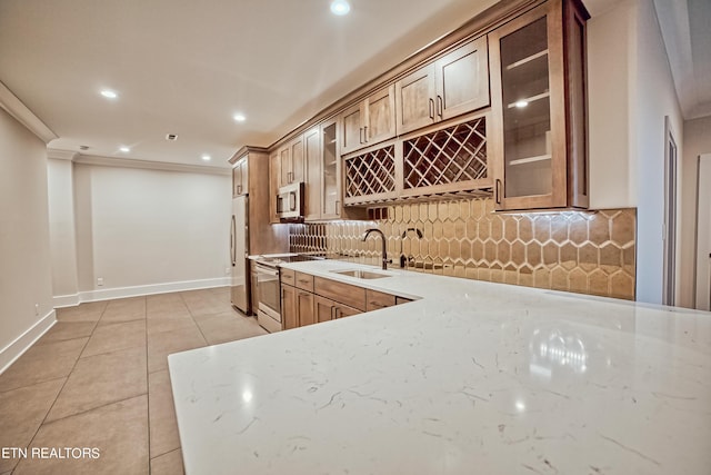 kitchen with stainless steel appliances, glass insert cabinets, a sink, and light tile patterned floors