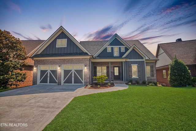 craftsman-style house featuring driveway, an attached garage, a yard, board and batten siding, and brick siding