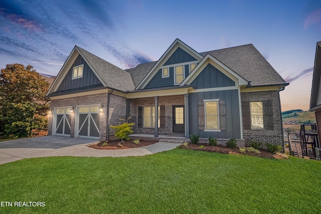 craftsman-style house with concrete driveway, an attached garage, a front lawn, board and batten siding, and brick siding