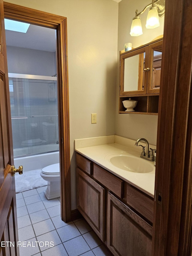 full bathroom with shower / bath combination with glass door, tile patterned floors, vanity, and toilet