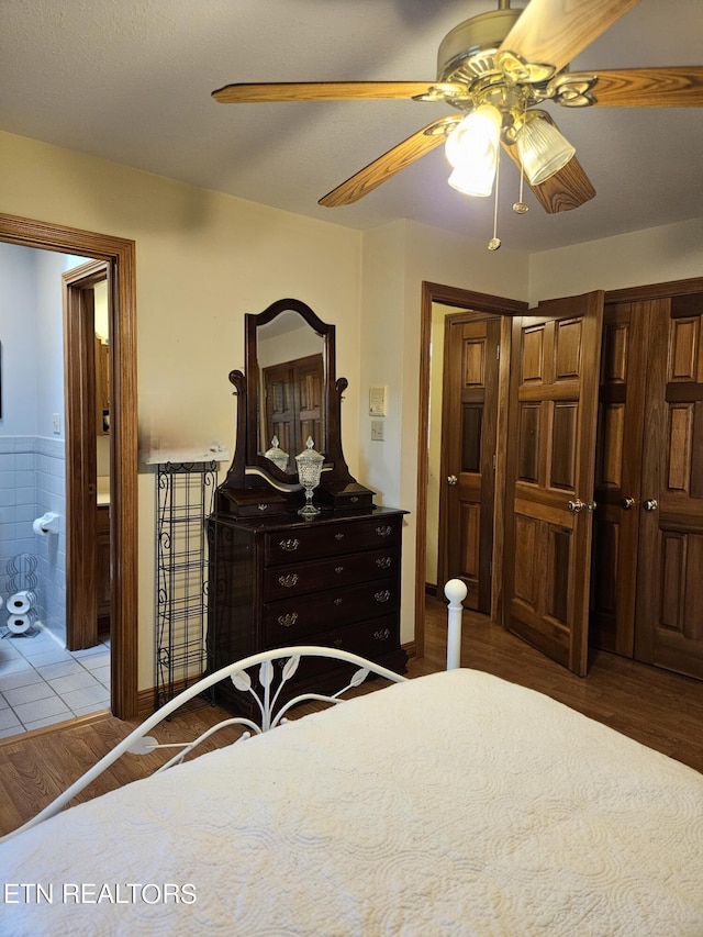 bedroom with connected bathroom, dark hardwood / wood-style floors, and ceiling fan