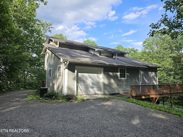 view of side of home featuring central AC unit, a garage, and a wooden deck