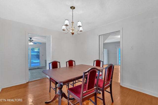 dining room with hardwood / wood-style flooring and ceiling fan with notable chandelier