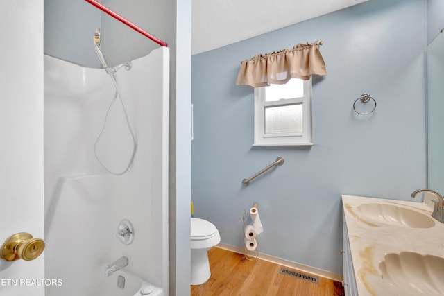 full bathroom featuring vanity, hardwood / wood-style flooring, toilet, and shower / bathtub combination